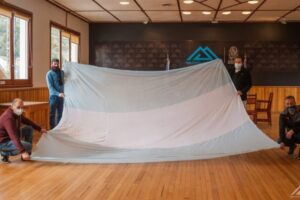 Lee más sobre el artículo Alta en el Cielo: San Martín de los Andes recibió parte de la bandera Argentina más larga del mundo 💙🤍💙